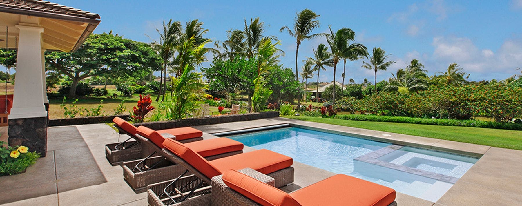 Lounge furniture by the pool at Kauai vacation rental home